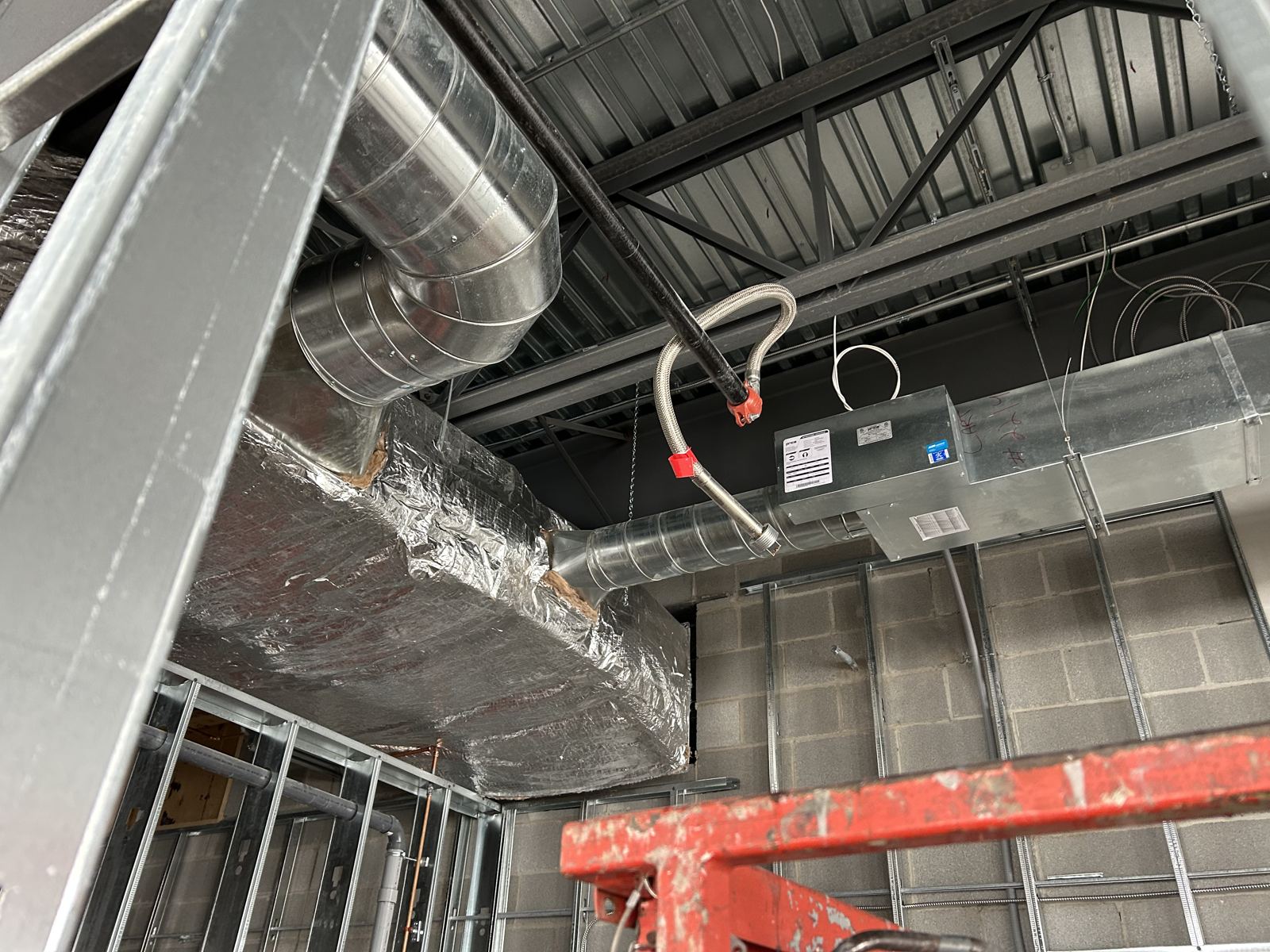 Insulated duct drop and pipe runs in an open ceiling