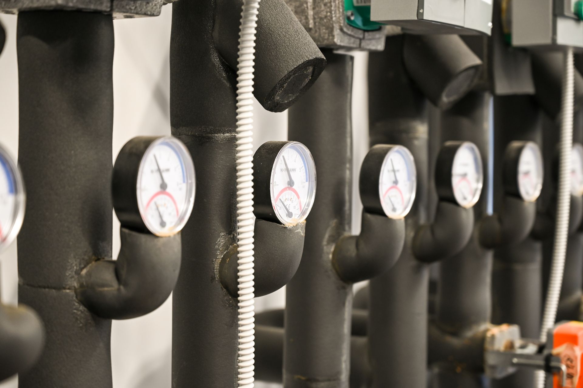 Insulated pipes with pressure gauges in a mechanical room